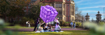Three students in the park near University buildings