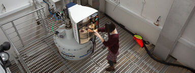 A researcher loads a sample into the 800 MHz spectrometer