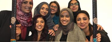 A group of women holding a 'celebrate - Muslim women's writing' on