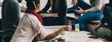A group of people meeting in an office and writing a mind map.