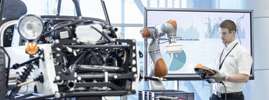 A man working with a robot at the Reconfigurable Assembly Integrated Demonstrator, or Project RAID, at Factory 2050