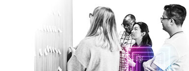 group of people looking at wall with post it notes