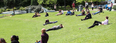 A diverse range of people sitting in a public park.