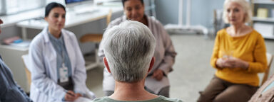 Group of patients and doctors seated in a circle