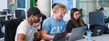 Three students are working together in computer room 3 in the Diamond.