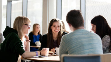 A group of students working together with hot drinks