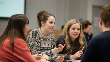 Students sitting at a table in discussion