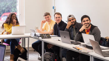 Students sat in a politics seminar engaged in discussion with tutor
