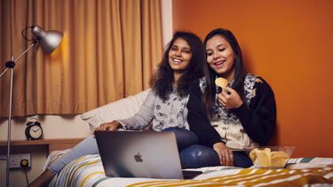 Students sat watching a laptop