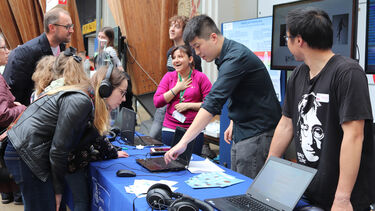 MRC Festival: stall, people using headphones