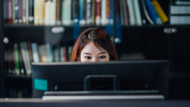 Student sat looking at a computer screen