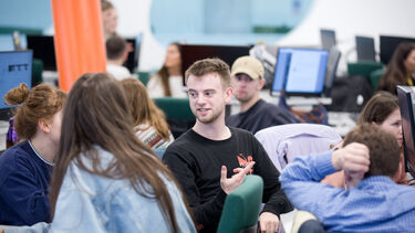 Students gathered around computers in the diamond doing group work