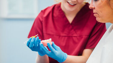 A dental hygiene student working with a patient - image 