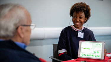 A student is working with a patient to complete tasks on an iPad