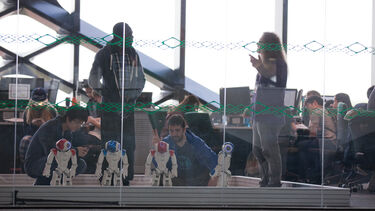 Students and staff working with robots. 