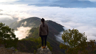 Student surveying the view from the top of a mountain as part of a field trip