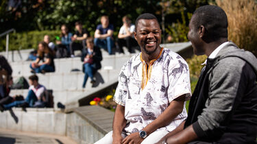 two students sit outside the students union 