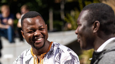 A student outside the students union smiling 