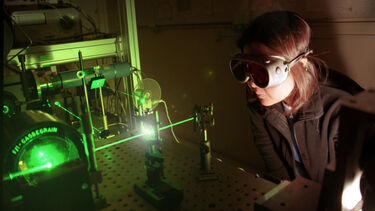 Student wearing goggles and experimenting with lasers