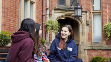 A group of students sat talking through Firth Court