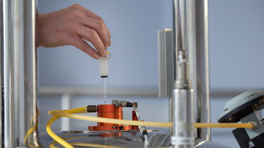 A researcher loads a sample into the 500 MHz spectrometer