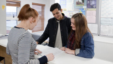 Photo of economics support staff speaking to students 