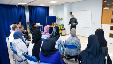 A clinician addresses a class