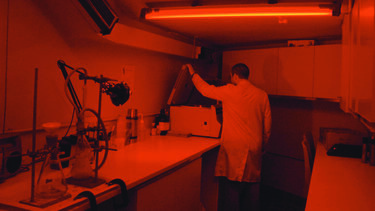 Person wearing lab PPE working in the luminescence lab