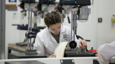 Engineering student using a piece of machinery