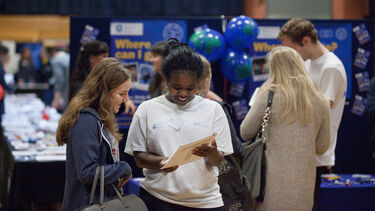 Two students reading a brochure at the Global Opportunities Fair.