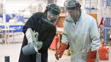 Student pouring molten aluminium into a mould