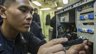 Electrician unscrewing a computer