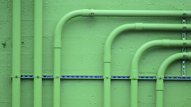 Green pipes on a green wall