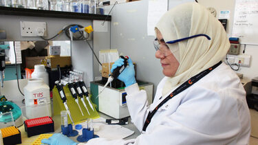 A researcher loads a sample with a pipette