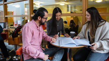 PGT students looking at a book
