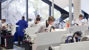Several researchers working in The Diamond. They are all wearing lab coats. 