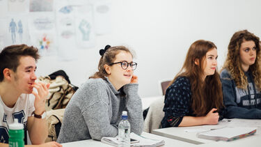 Four students listening in a lecture. 