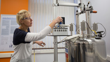A scientist loads a sample onto a NMR machine.