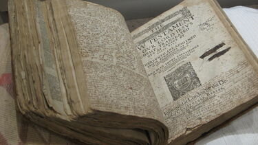 Old bible laying open on a table showing the New Testament