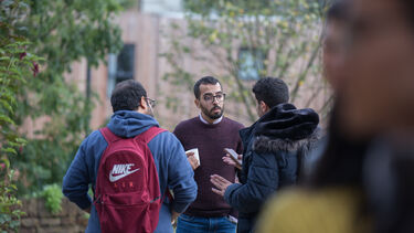 Three PhD students chatting outside