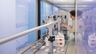 A researcher loads a sample into a SAXS instrument