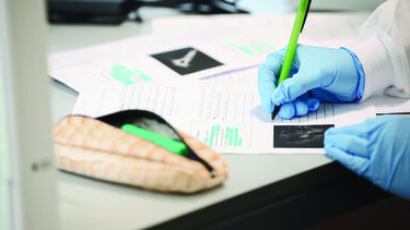 A bioengineering student taking notes in a lab
