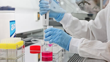 A bioengineering student measuring out liquid with a pipette