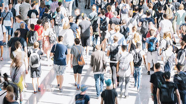 A large group of people in public. It's sunny - they're dressed for summer.