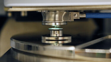 An image of a green light shining on the probe of the atomic force microscope