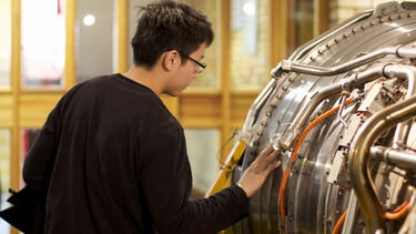 A student studying a piece of machinery
