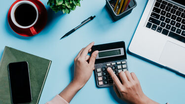 A woman using a calculator represents funding.