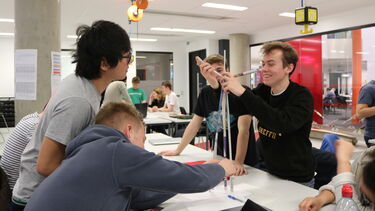 Students building a tower out of newspaper