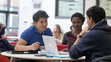 A group of students looking at a laptop
