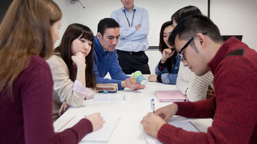 A manager oversees a group of employees in a meeting.